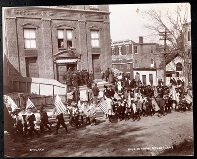 Young boys with flags marching in a parade at Dobbs Ferry, New York, 1898 by Byron Company